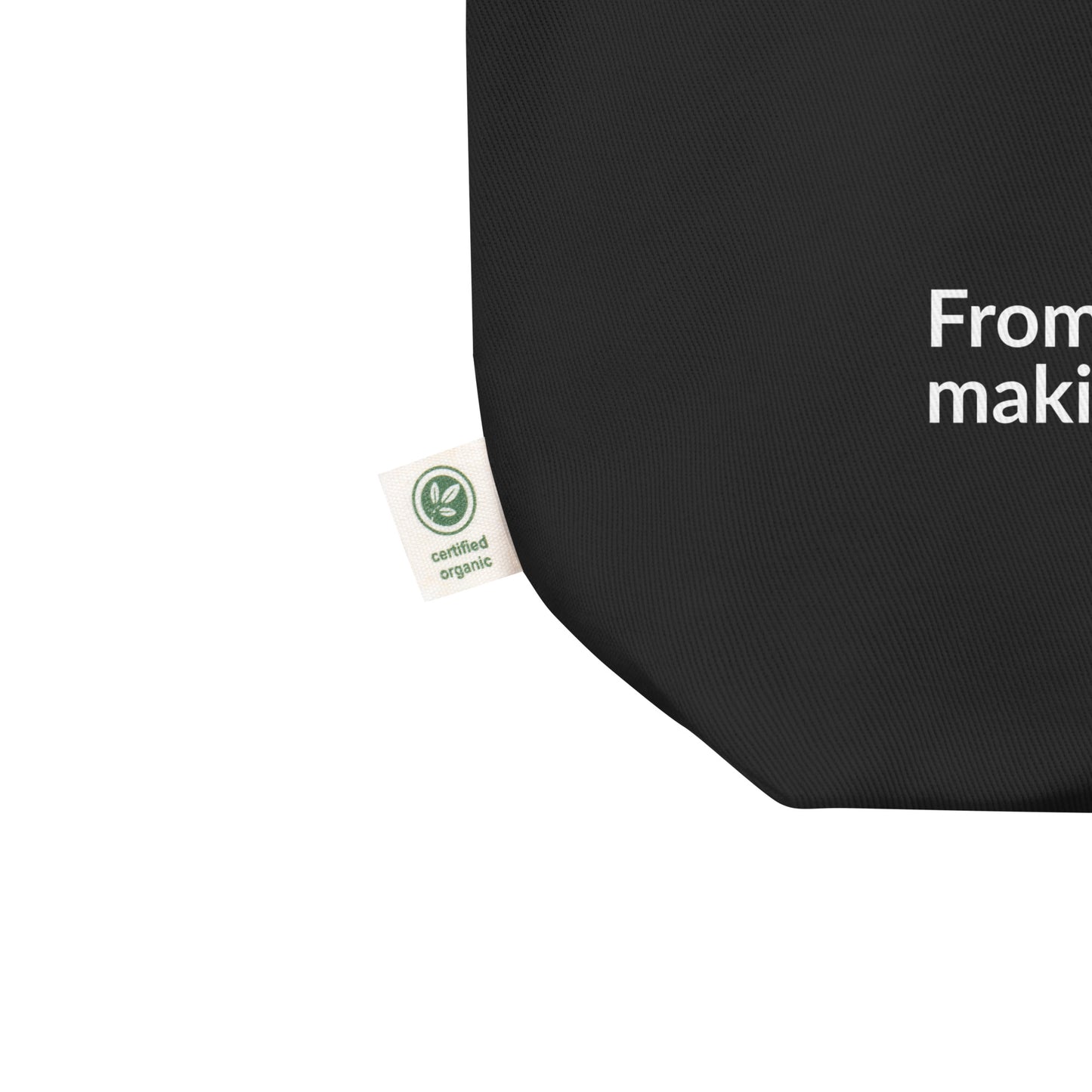 Black eco tote bag with a green label certification, on a white background