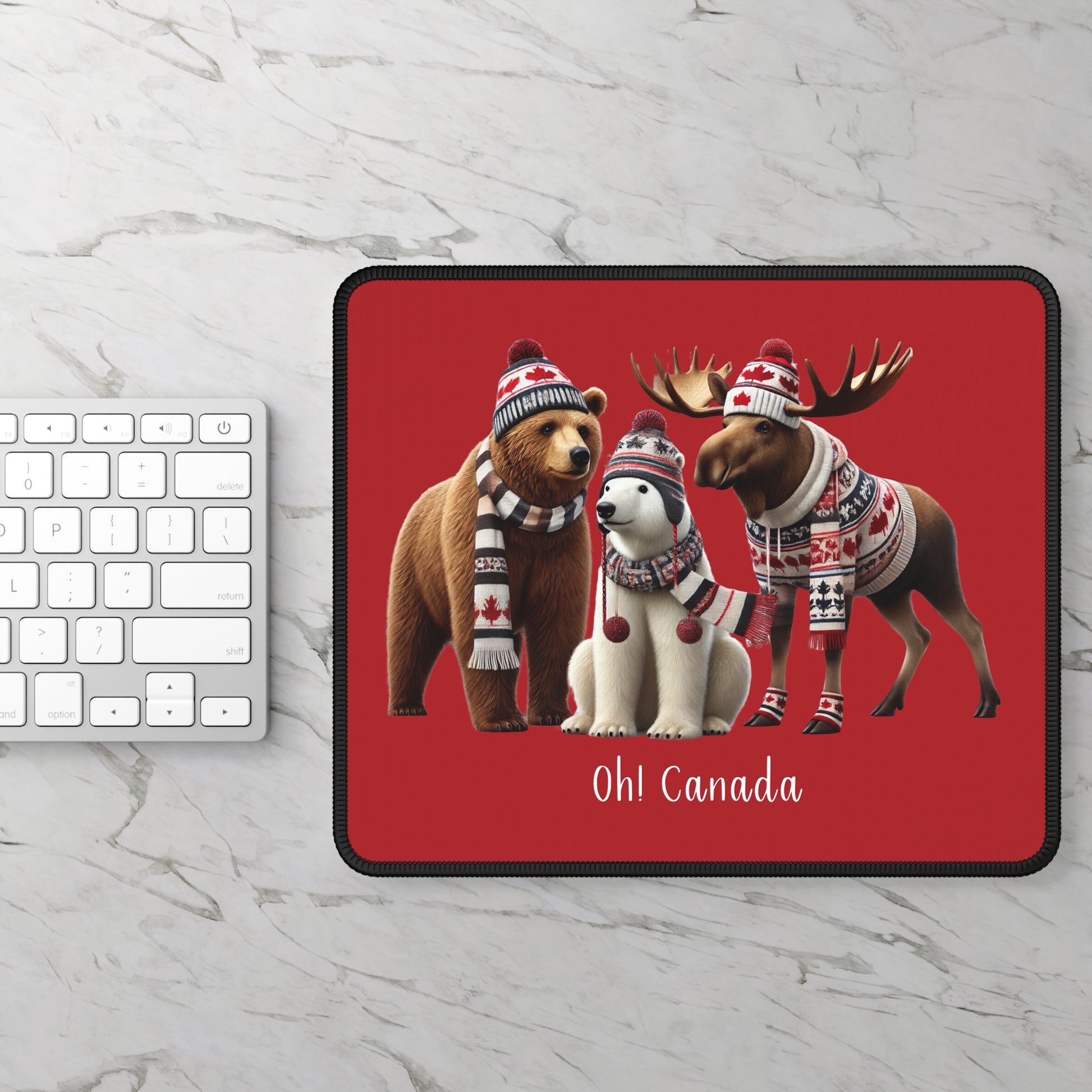 Mouse pad with Canadian-themed animals on a red background, placed on a marble surface with a keyboard.