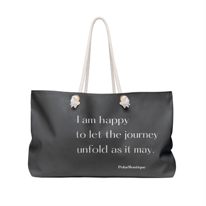 Gray tote bag with a quote and brand name on a white, background