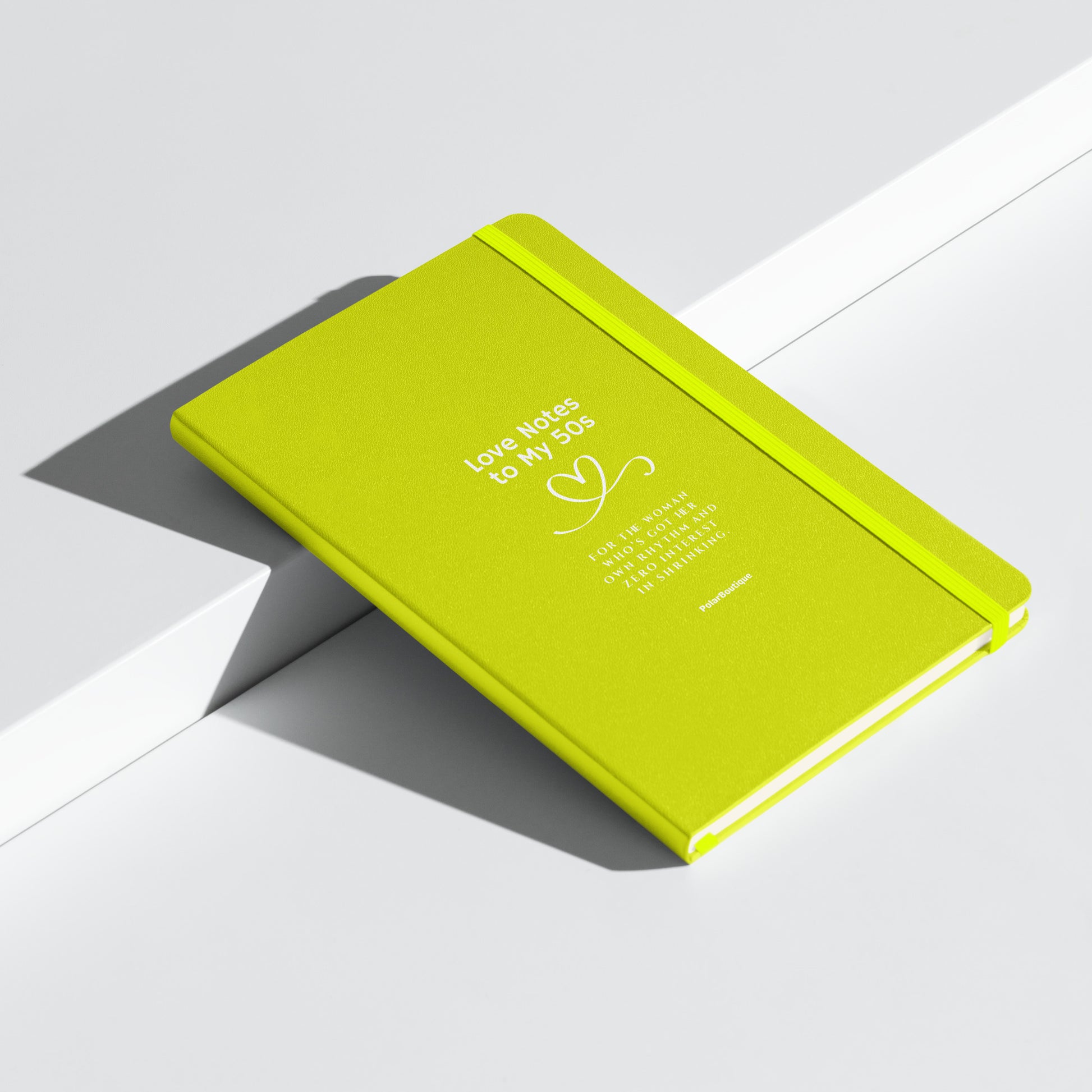 Green notebook with text on a white background angled