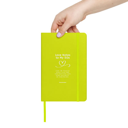 Hand holding a lime green notebook with text on a white background