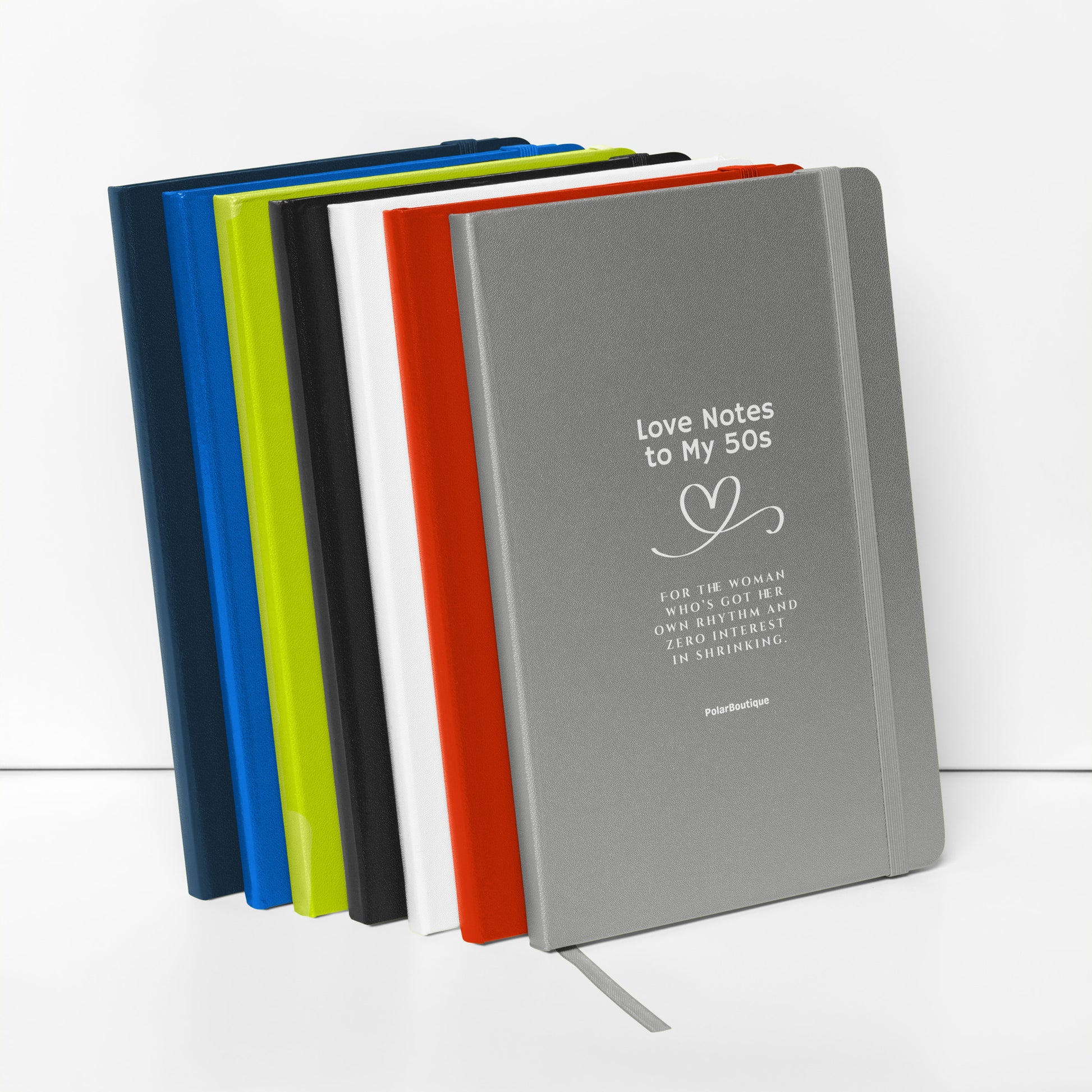 Set of colourful notebooks with a silver one featuring 'Love Notes to My 50s' text.